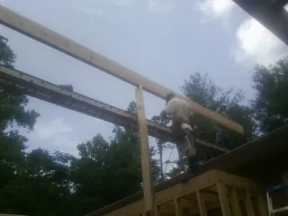 Carpenter setting a ridge beam over a new addition frame — Ice Dam Removal by Roofing Brothers in Scotch Plains