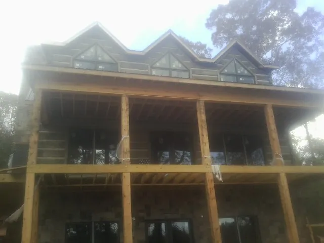 Dormers and porch framing on a large log home under construction — Roof Coating work by our crew in Scotch Plains