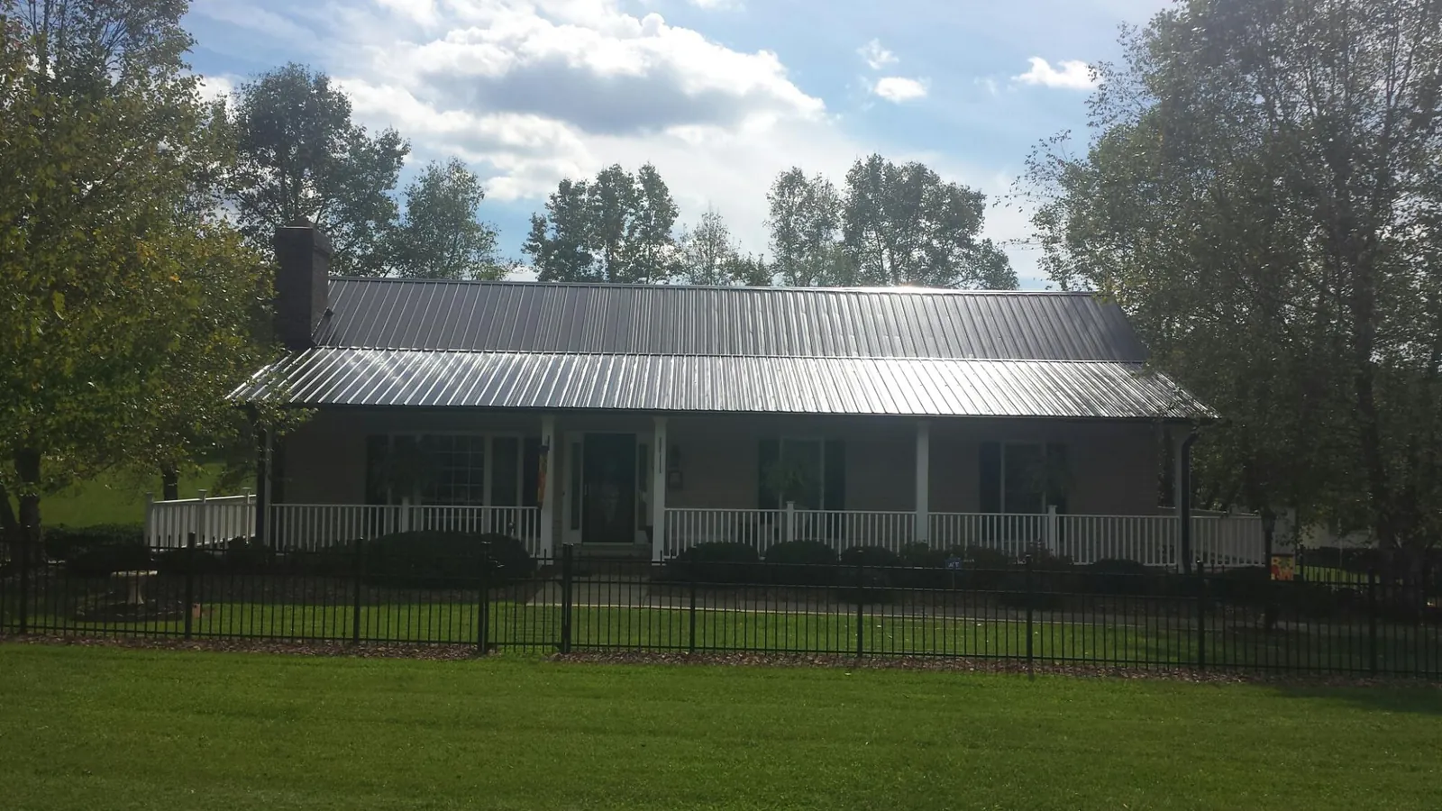 Gray metal roof on a brick ranch with a full width front porch — Gutter Guard Installation work by our crew in Scotch Plains